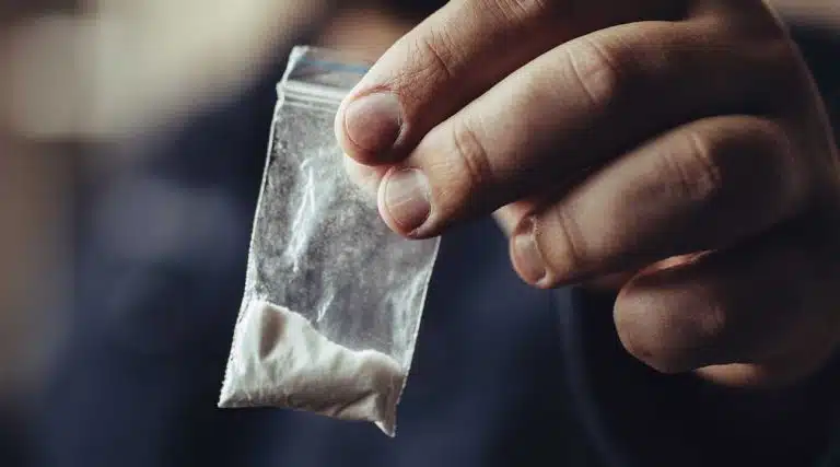 man holding a bag of powder cocaine