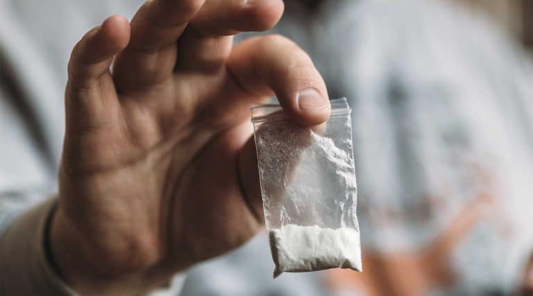 man holding a bag of heroin