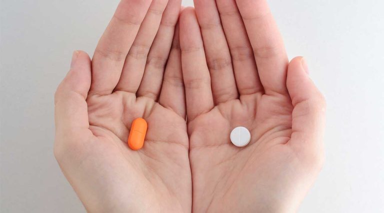 woman holding two different types of prescription drugs opioids or opiates