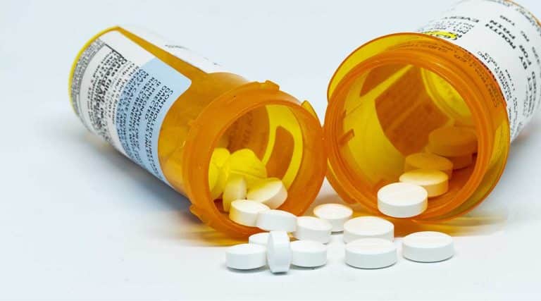 two bottles of prescription opioids spilled on a table