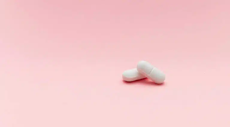 whire pills hydrocodone pink background