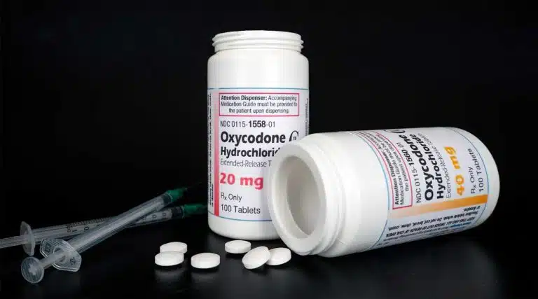 syringes next to two bottle of Oxycodone Hydrochloride