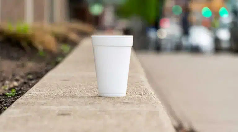 white styrofoam cup on a street curb