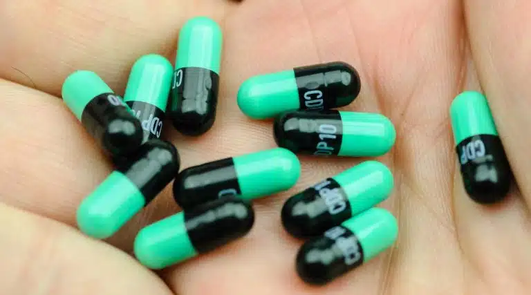 woman holding black and green pills Librium Chlordiazepoxide