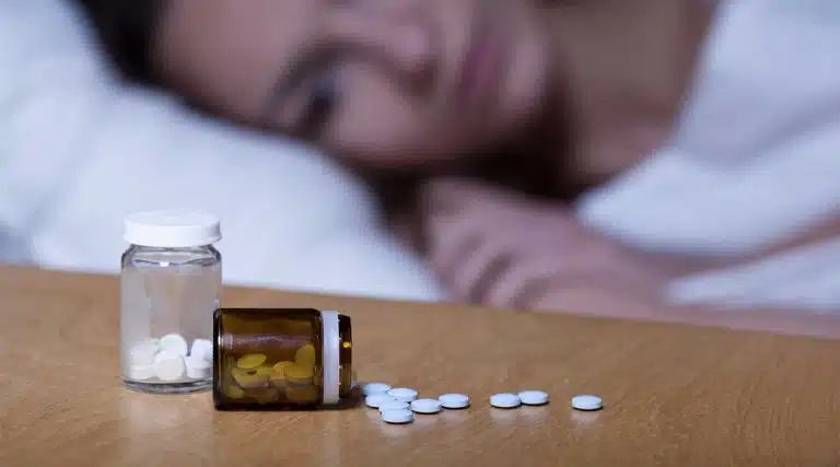 tired young woman comparing Restoril vs Ambian sleeping pills