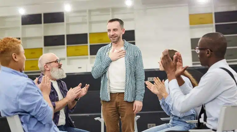 man standing up during an alcoholics anonymous meeting