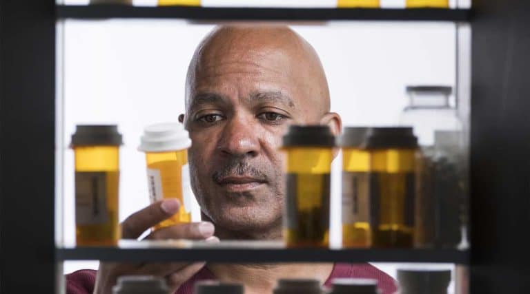 man looking into a medicine cabinet to see if xanax is and opioid