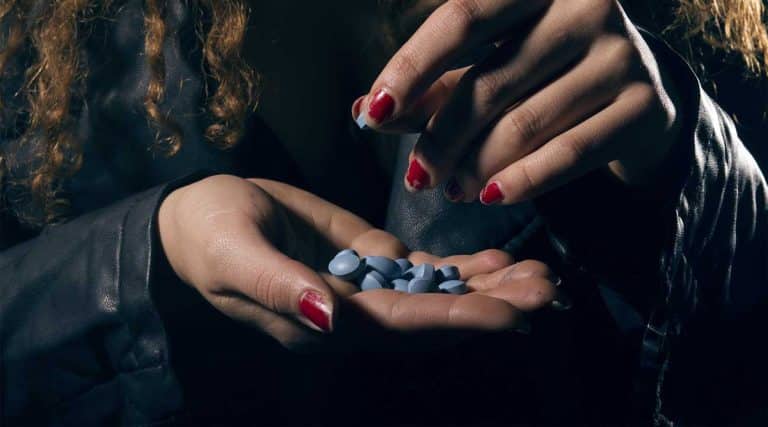 woman holding xanax blue pills Xanax Overdose signs