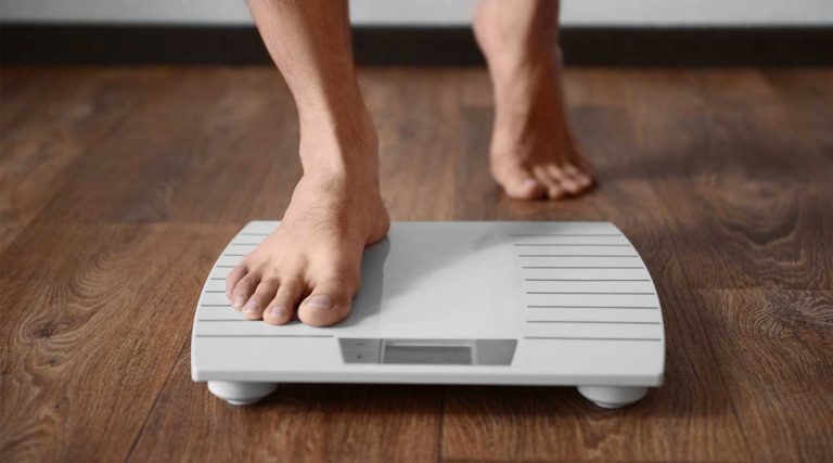 man stepping onto a scale to check his weight xanax weight gain and weight loss