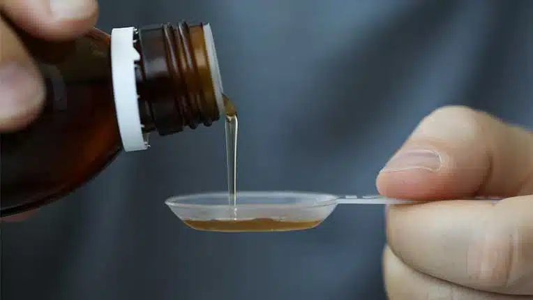 man pouring cough syrup - Fake Codeine & The Dangers Of Counterfeit Medicine