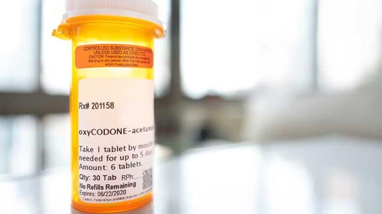 oxycodone orange pill bottle on table - Oxycodone Side Effects