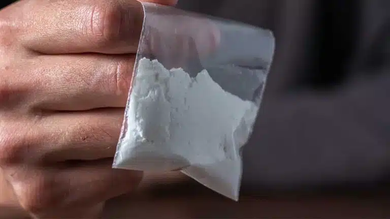 hand holding small bag of white powder cocaine - Fake Cocaine | Identification, Risks, & Effects