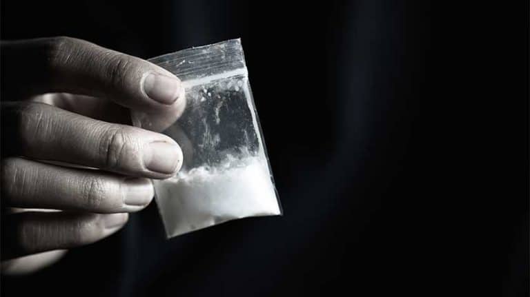 hand holding small bag of white powder - Fake Heroin & The Dangers Of Fentanyl-Laced Street Drugs