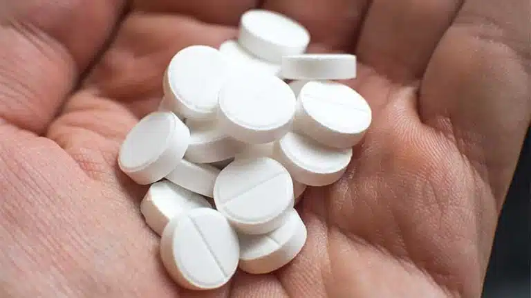 man attempting to take a handful of lexapro pills - Lexapro Overdose | Signs & Safety Precautions