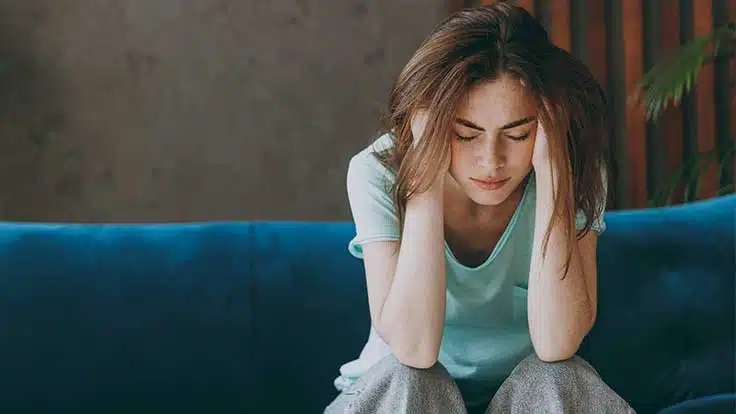 woman with a headache holding her head - Lexapro Withdrawal | Symptoms, Timeline, & Detox