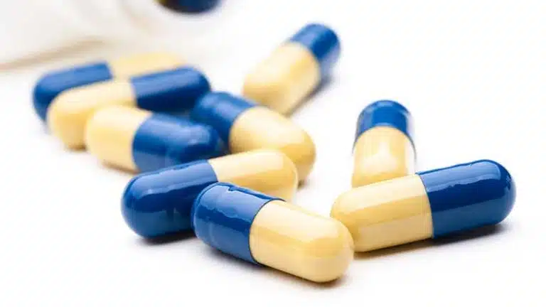 blue and yellow pill capsules - Strattera (Atomoxetine) Abuse, Addiction, & Treatment Options